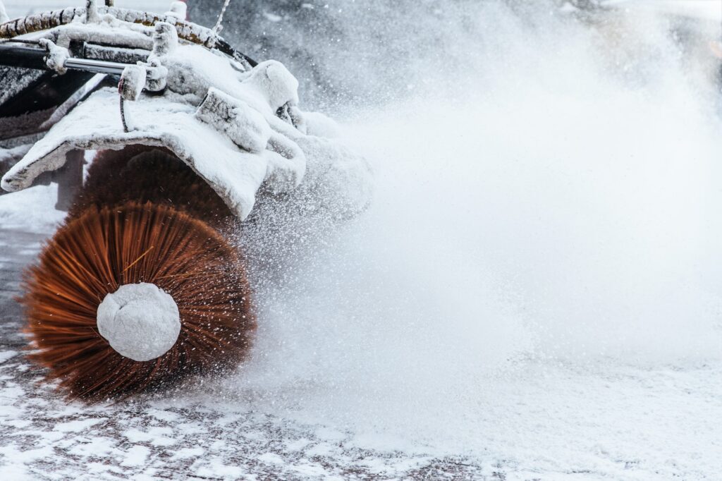 Snow plow does removal after blizzard in winter. Snow blower in motorway. Winter service on road